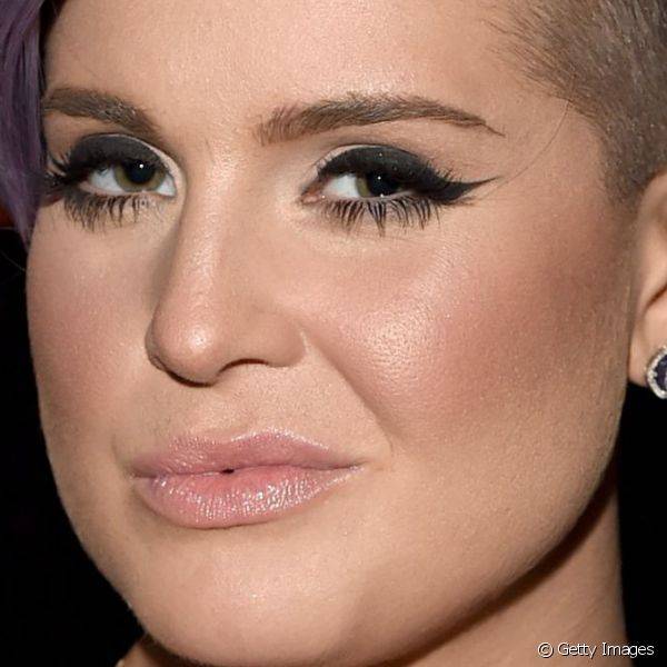 O delineador preto com tra?ado alongado j? se tornou marca registrada na maquiagem de Kelly, como usado no amfAR Inspiration Los Angeles Gala, em outubro de 2014